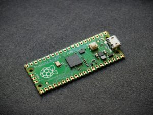 Microcontroller board with Raspberry Pi logo and USB port.
